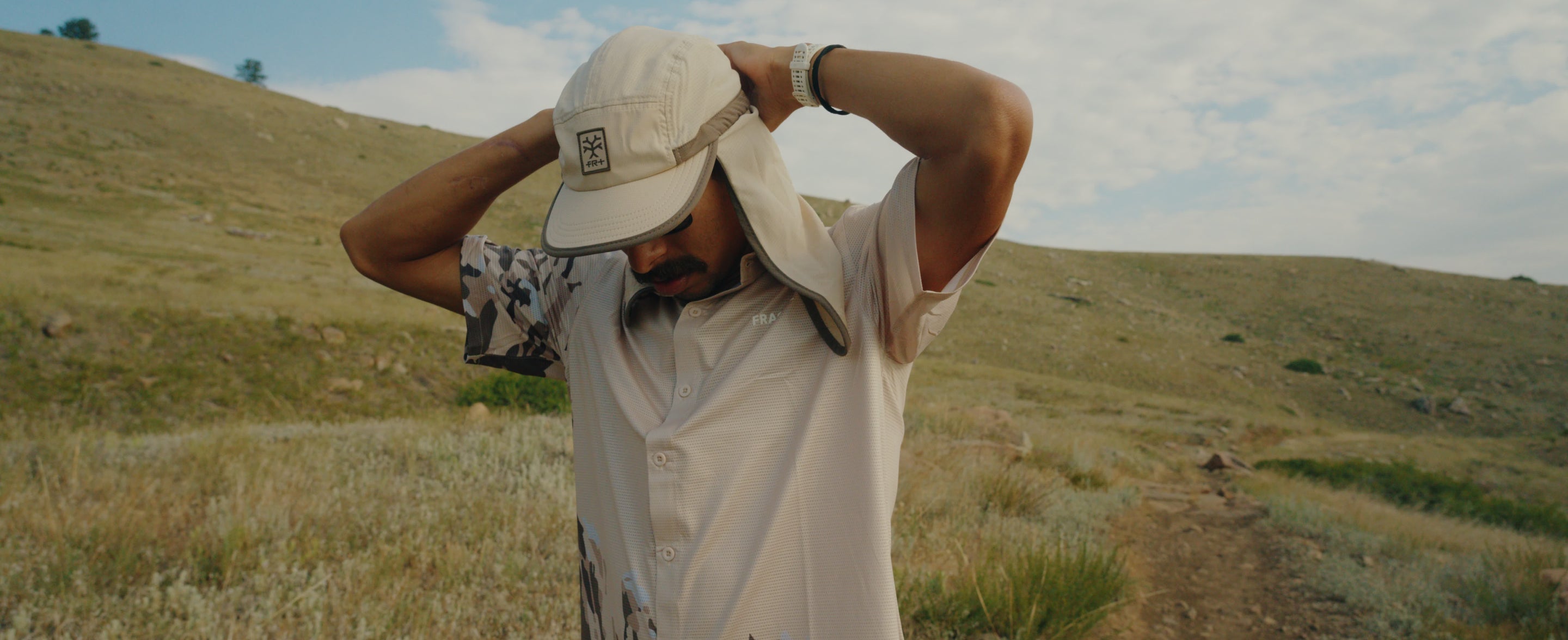 A runner wearing Fractel's Rockies legionnaire hat in Rocky Mountain National Park