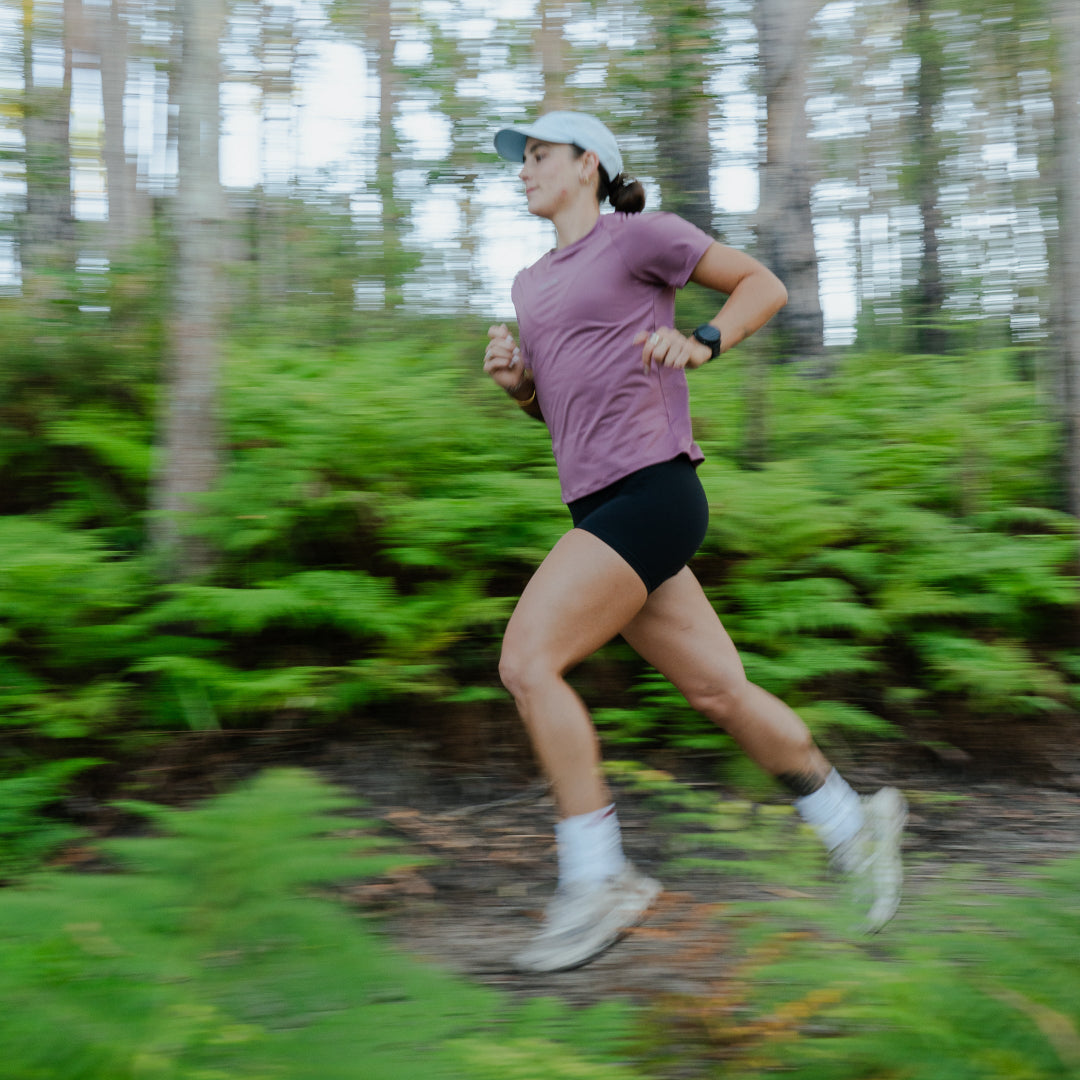 Woman running through a forested area