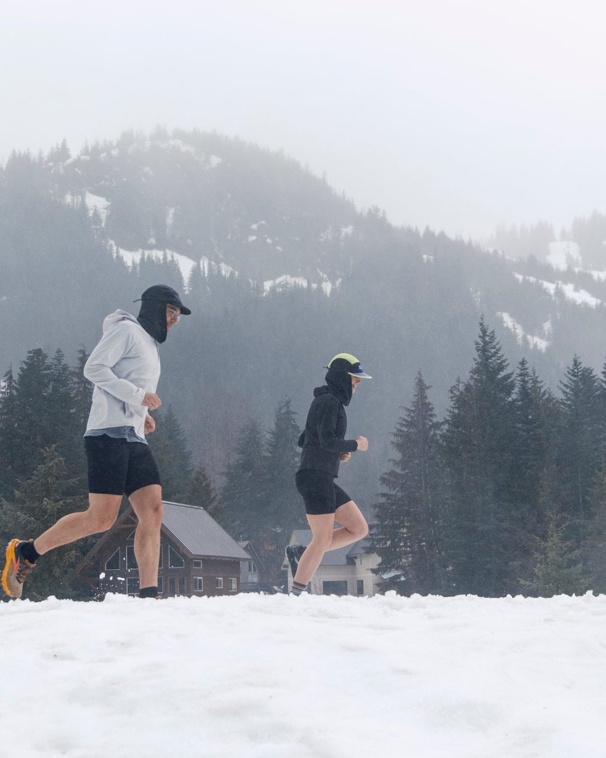 Winter running gear: runner in a Fractel cap and neck gaiter running through snow