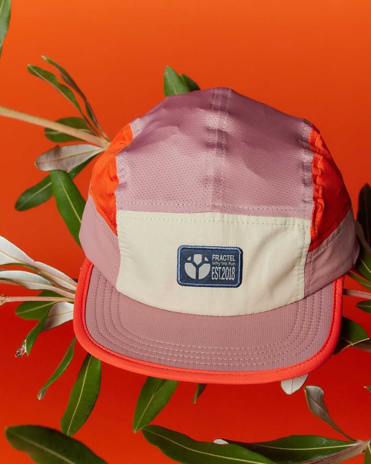 M series seasonal running cap with a navy Fractel patch among olive leaves