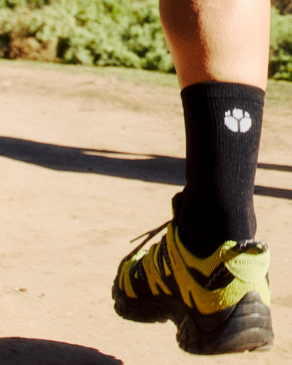 Black Fractel mens running socks worn on a dirt trail