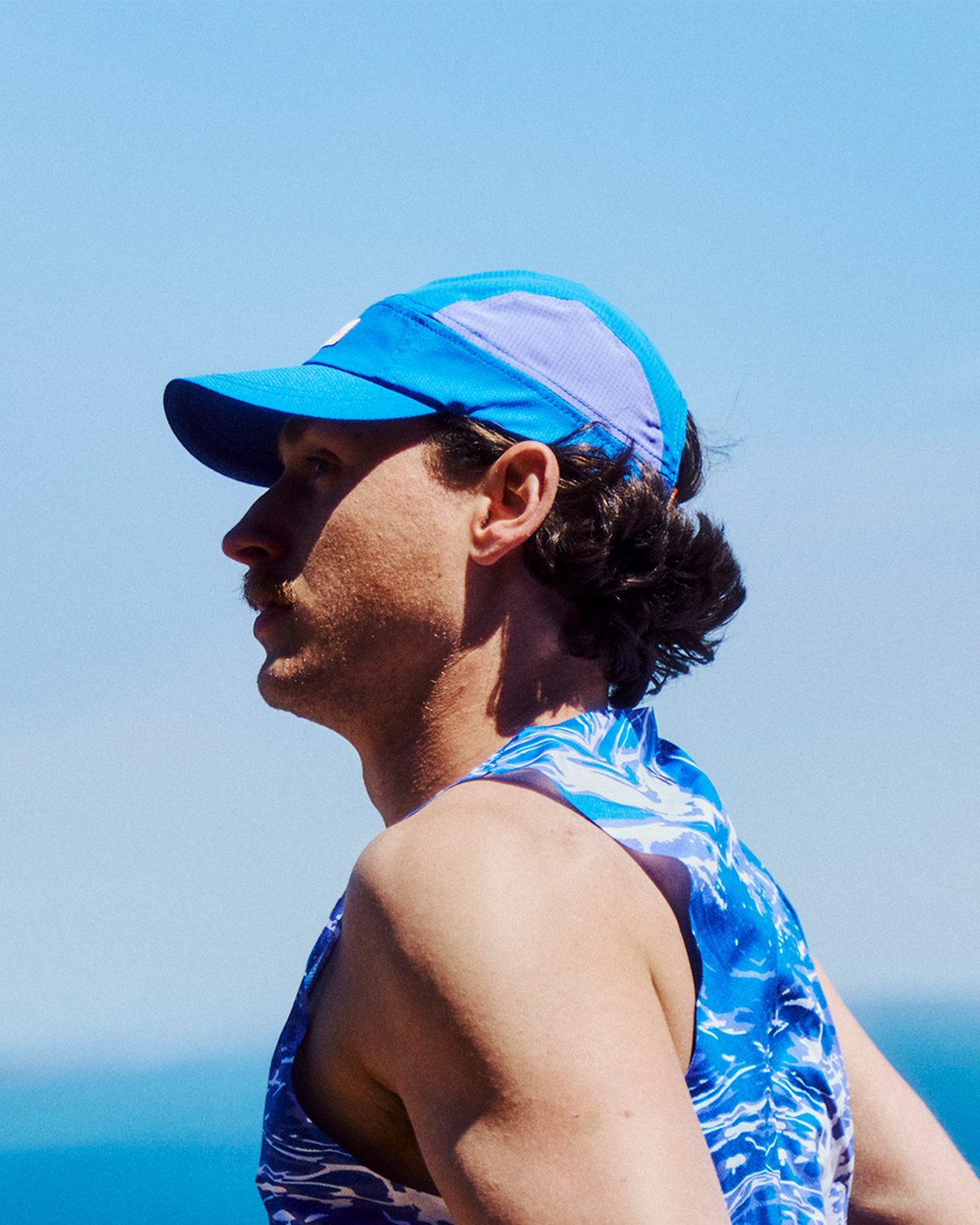 Race day running cap in bright blue, a minimalist racing cap worn on the coast