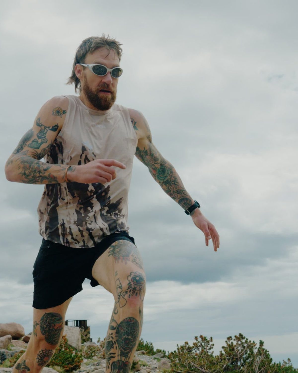 Mens running tanks: printed Fractel singlet with black shorts on a hilltop run