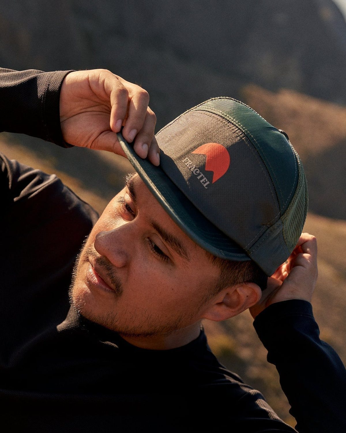 Trucker cap for running: dark green Fractel cap with a sunrise logo