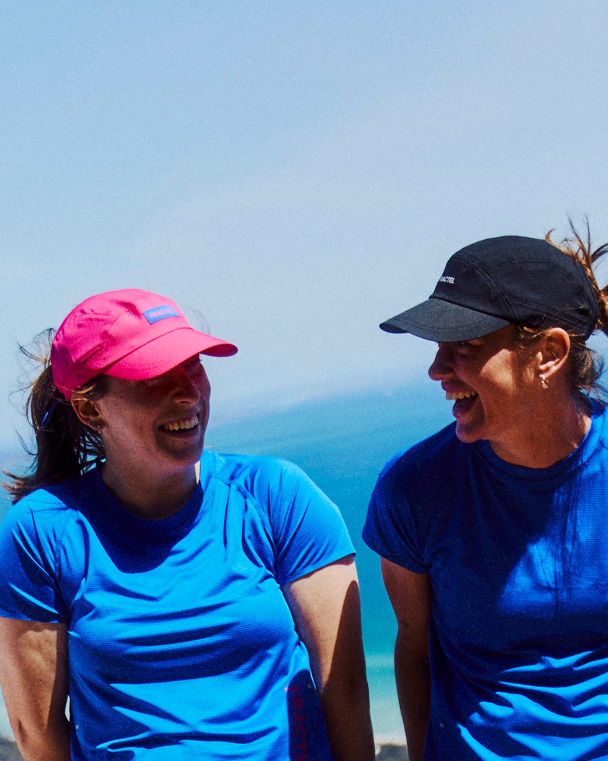 Womens running tops: bright blue Fractel running shirt worn by a laughing runner